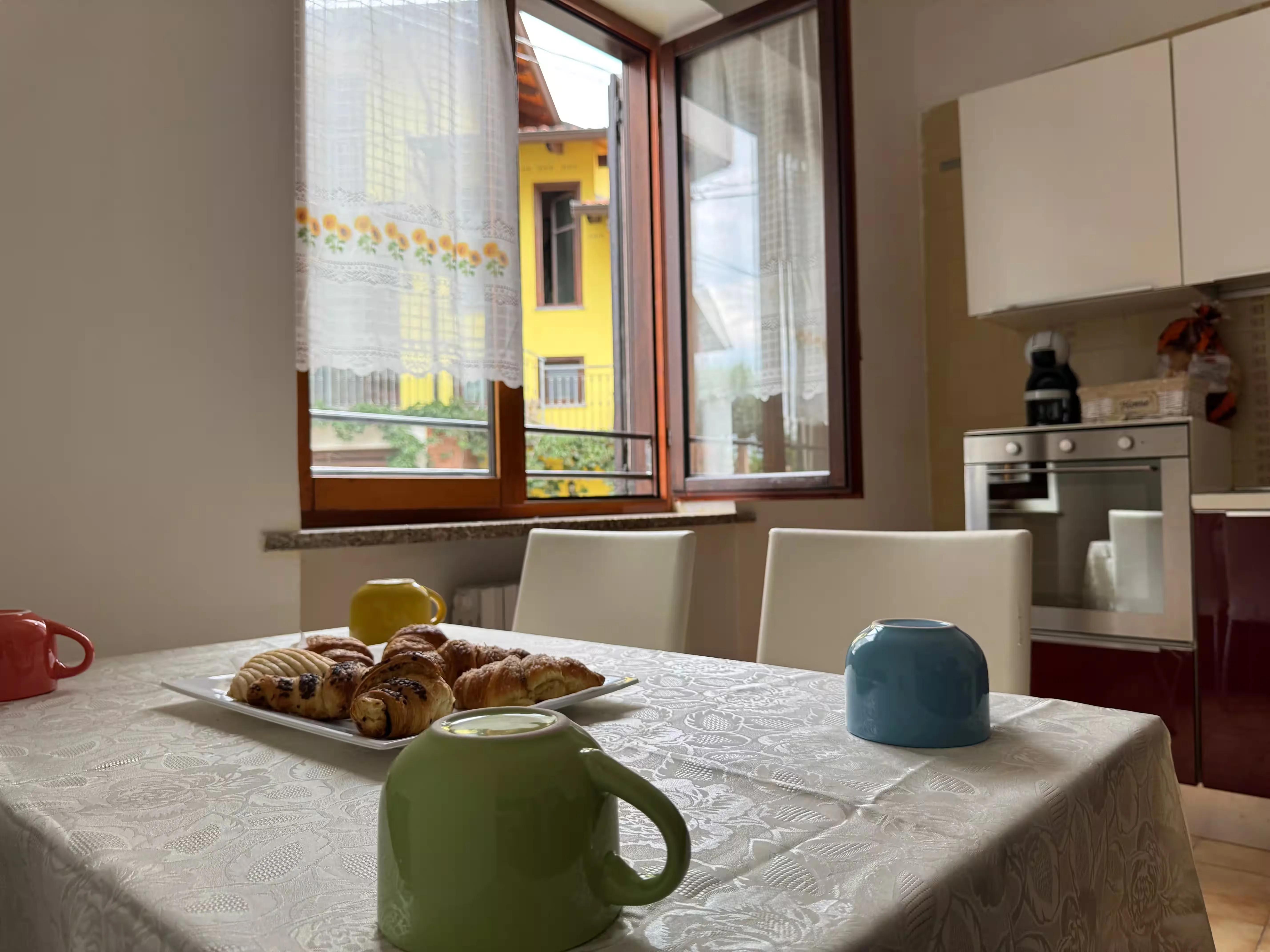 Colazione in cucina con cornetti e tende a girasole - Villa Sole Roasio